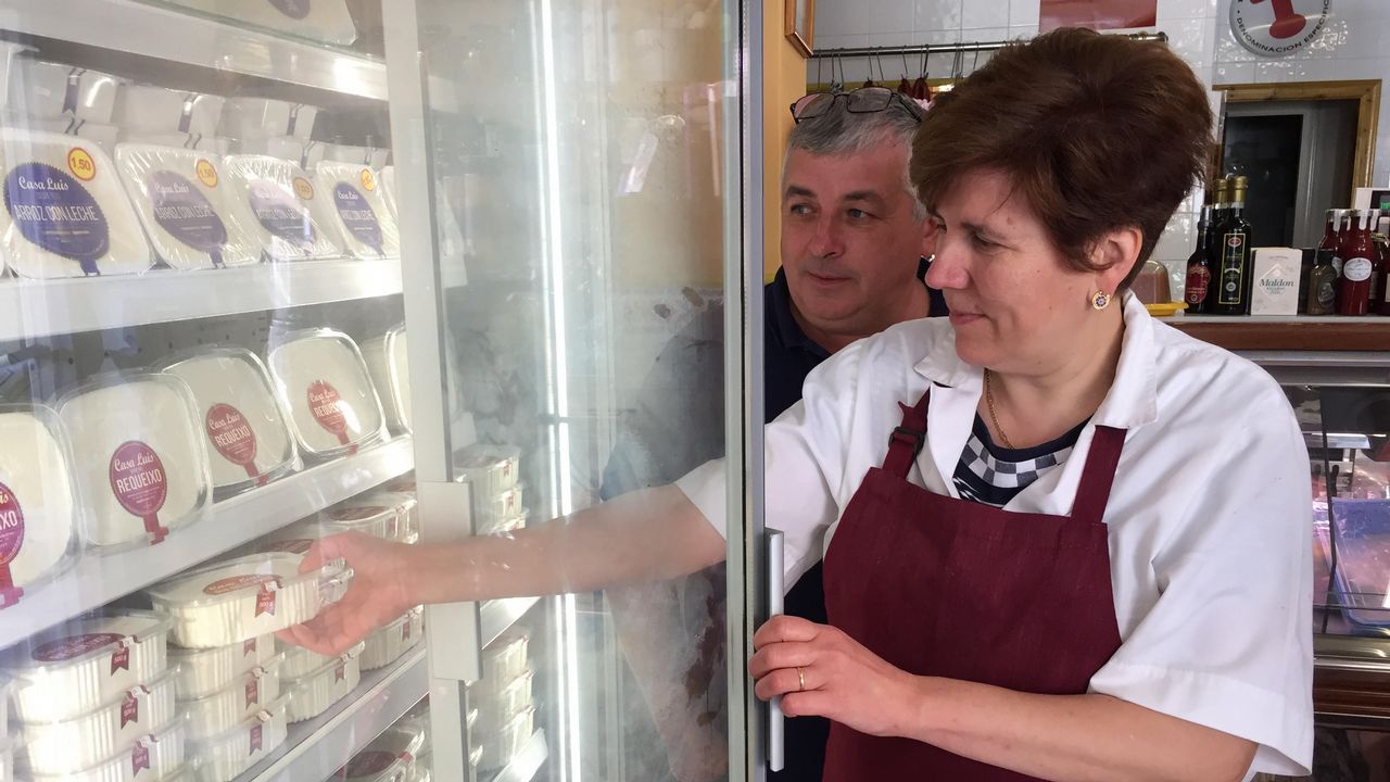 Familia de Casa Luis sacando requeixo artesano de la vitrina en Lourenzá